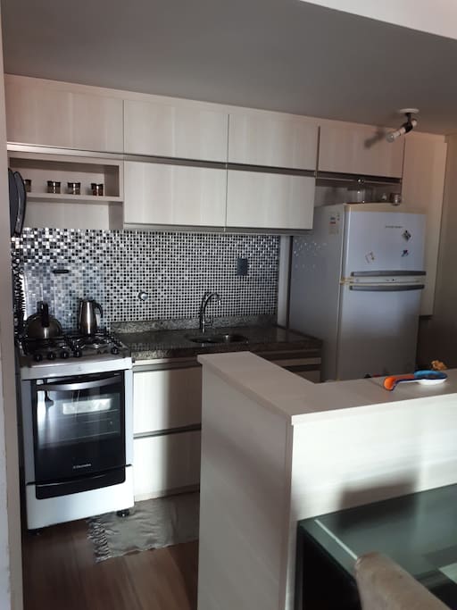 Cozinha amaricana com fogão 4 bocas, microondas, geladeira e gelagua