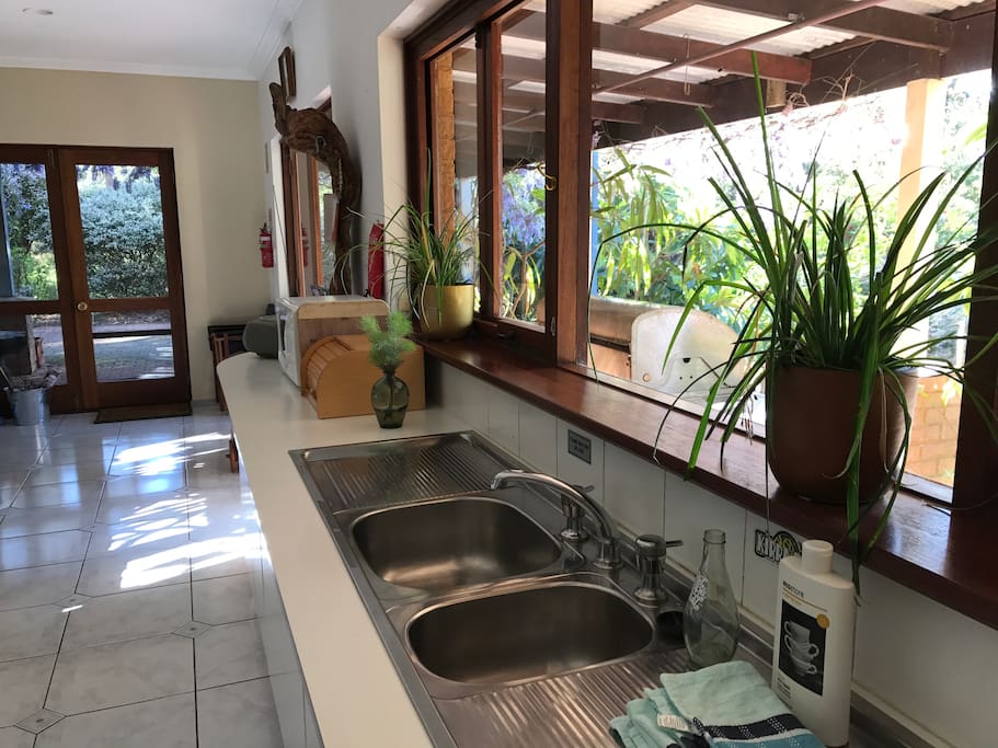 Enjoy preparing meals in the spacious kitchen while looking out over the bush and garden