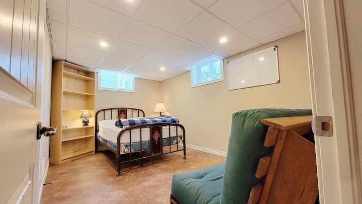 Camera da letto seminterrata con letto matrimoniale e divano futon