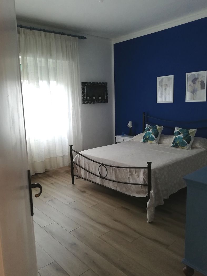 Светла родителска спалня с вентилатор на тавана 