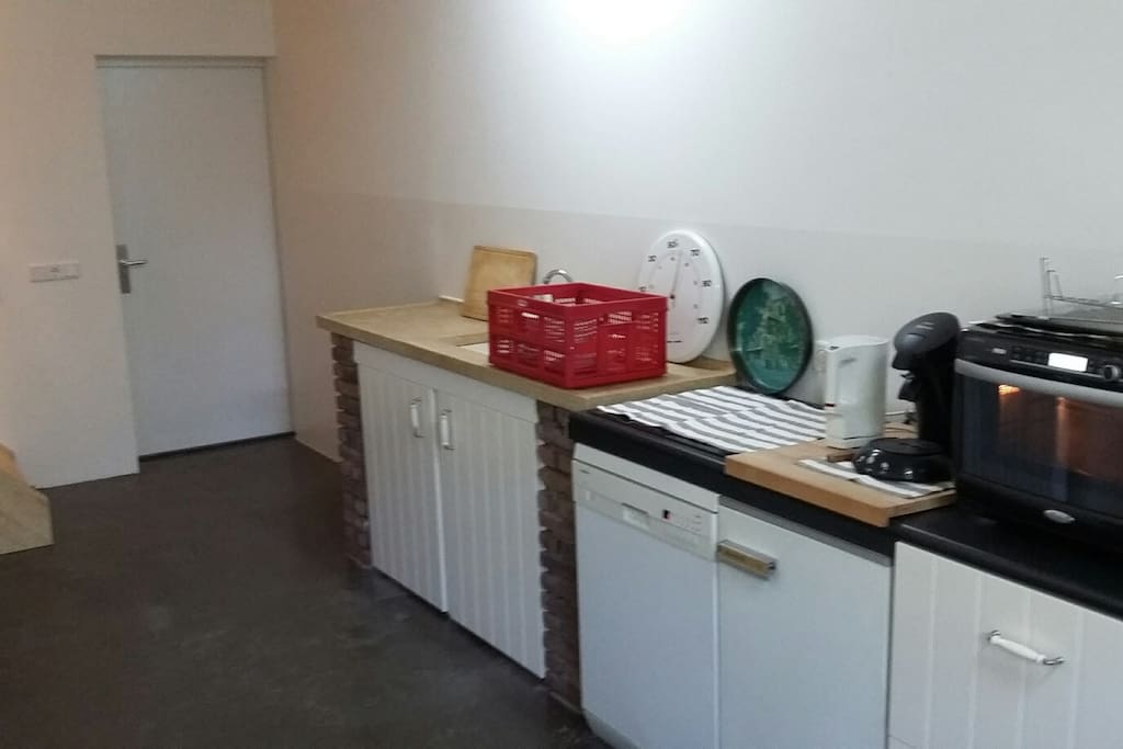 Keuken met koelkast, vaatwasser, 4 pits inductie plaat en combi magnetron.