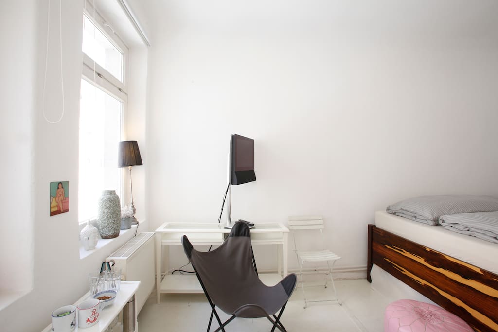 Schlafzimmer mit Sessel und Fernseher