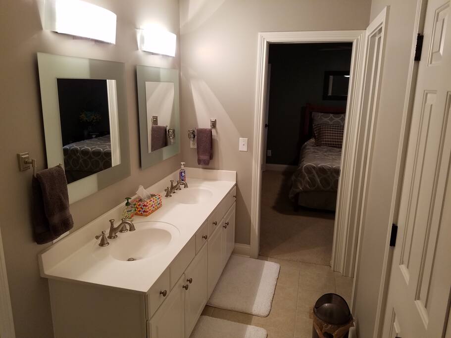 Shared bathroom for bedrooms 1 and 2. Double sink, pocket door separates stool and bathtub/shower.