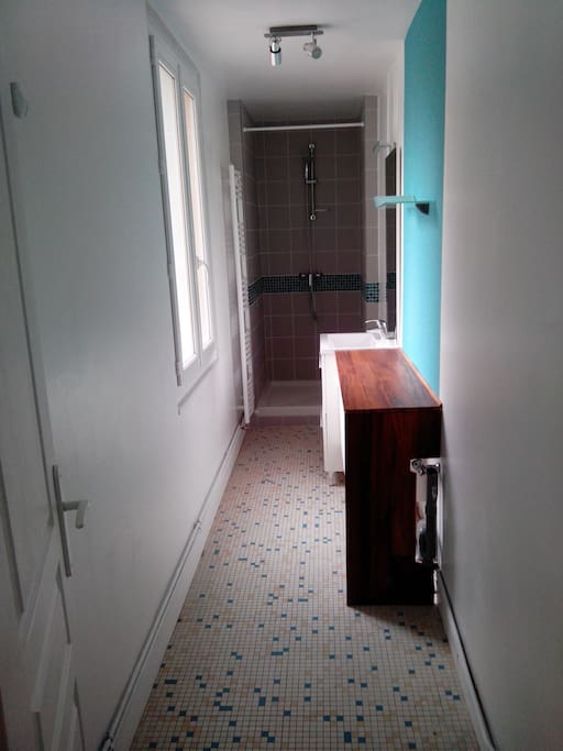 La lumineuse salle de bain avec gel douche, shampoing, soin de peau et serviette à votre disposition.