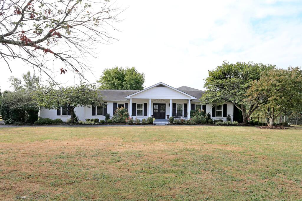 Front of house as taken from road, 2 entrance driveway, lane to barn on left, playground on right.