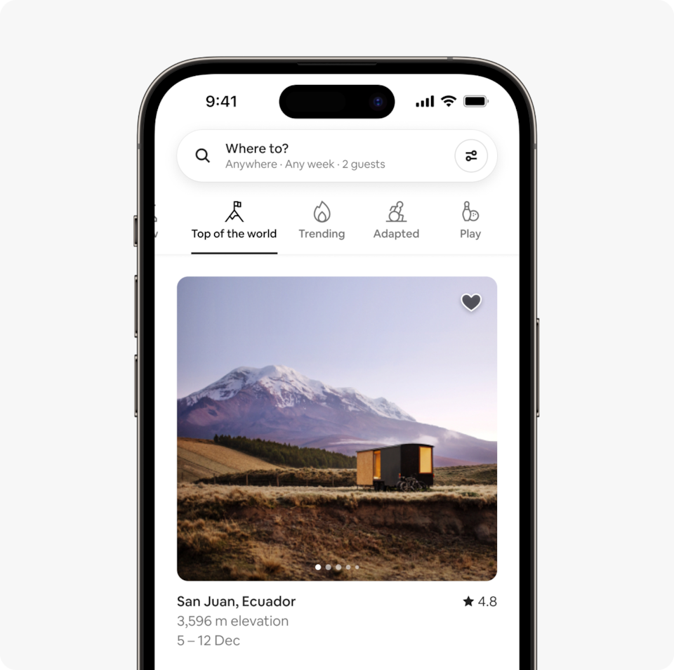 A laptop and a phone show the Airbnb homepage with two rows of homes from a new Airbnb November Release category called Top of the world, which features homes at high altitudes; around 3000 metres (10,000 feet) above sea level.
