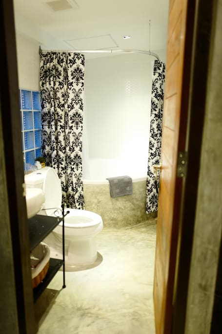 A clean bathroom with a luxurious bathtub and hot/cold water.