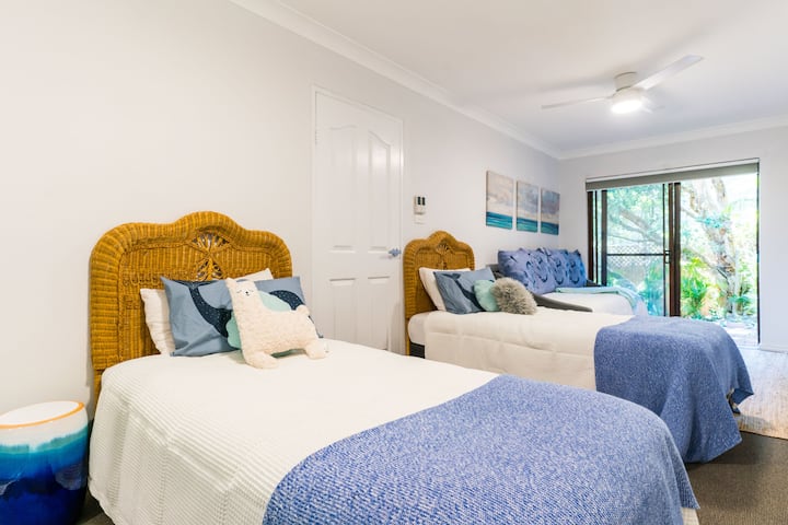 La troisième chambre, située au rez-de-chaussée, dispose de deux ventilateurs de plafond, de deux lits simples, d'un peignoir intégré, d'un lit de jour et de son propre accès à la spacieuse cour extérieure.