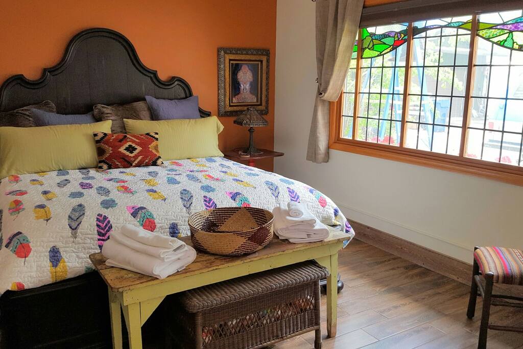 king bed with beautiful stained glass window