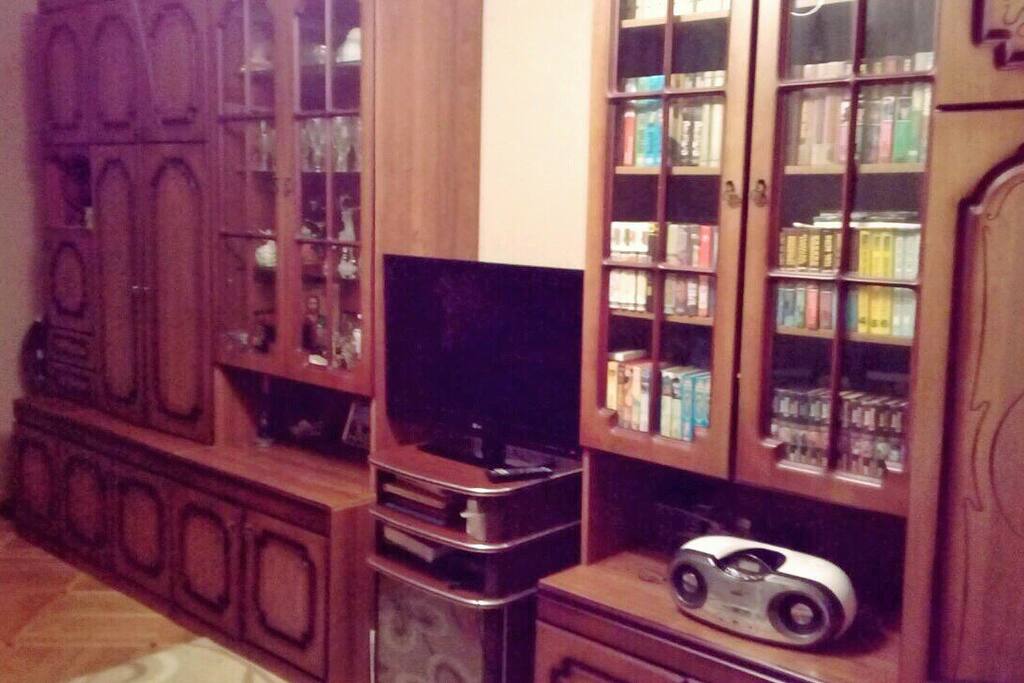 Large room of 18 square meters with a large sofa, a TV, a wardrobe and a work table