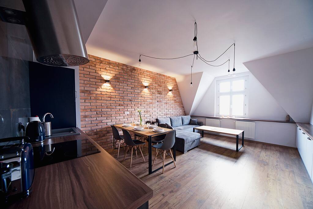 Salon z aneksem kuchennym i dużą sofą