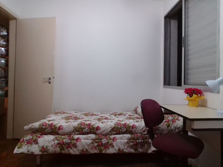 Clear and well-ventilated room with a partial view of the street. / Quarto claro e bem ventilado com vista parcial para a rua.