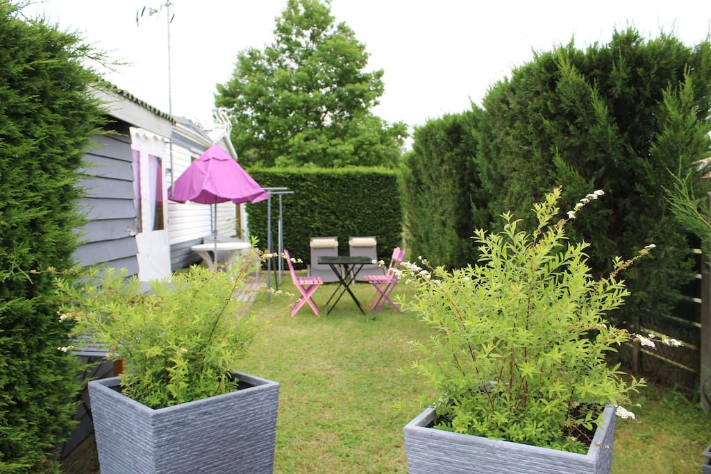 Une partie du jardin avec coin repas + plancha + bains de soleil