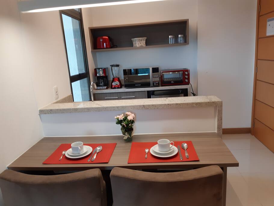 Pequena cozinha e mesa de refeição e trabalho