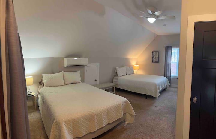 El huésped de nivel superior en suite con dos camas tamaño queen y baño completo adjunto. 
Vista desde la puerta.