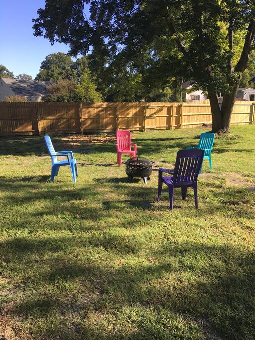 Big fenced in backyard with fire pit.