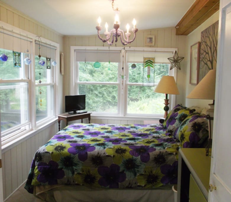Your bedroom. The room has windows that surround your bed on 2 sides. This gives you a great view of the backyard. It feels as if you are staying in a treehouse since the bedroom is 0ne flight up above the backyard, which is totally surrounded by woods. The deer and wild turkeys graze in the back yard.