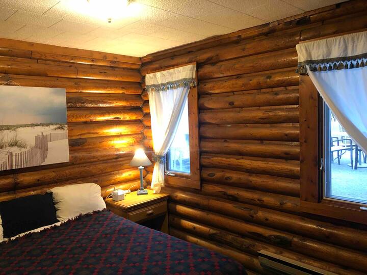 The log bedroom features a queen size bed and is located across the hall from a full bathroom 