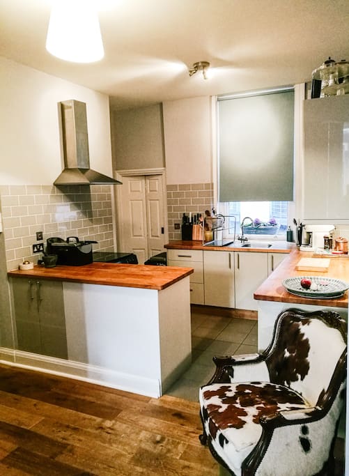 Open-plan, fully equipped kitchen with separate laundry area