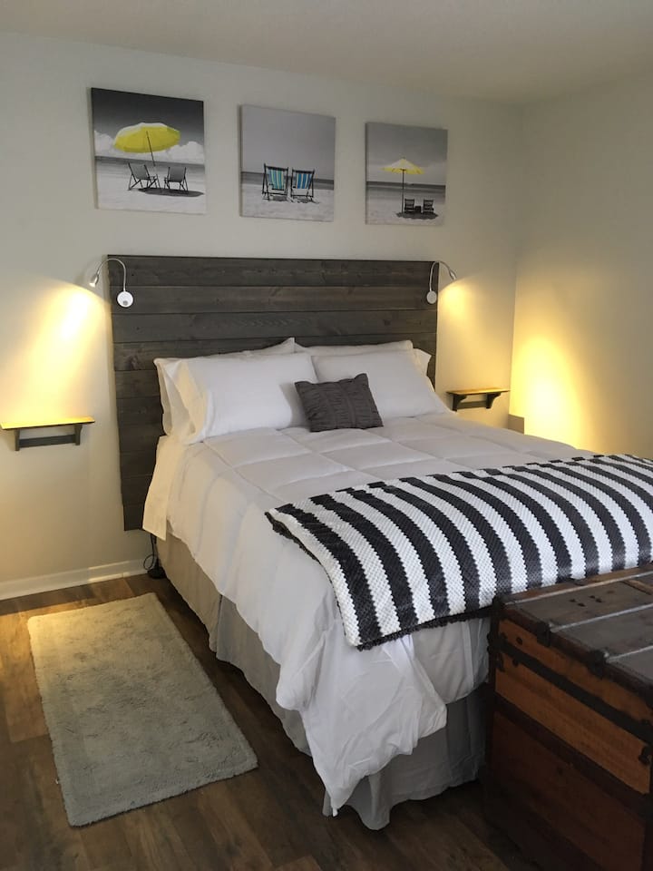 Extremely Comfortable Queen sized bed with duvet cover and high quality pillows is equipped with reading lights and floating shelves for electronics and conveniently located USB plugs.