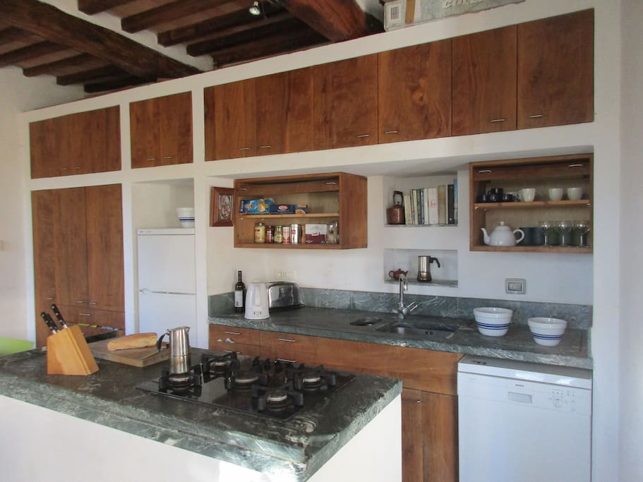 Kitchen, with marble counters, platano cabinets, cooking island.