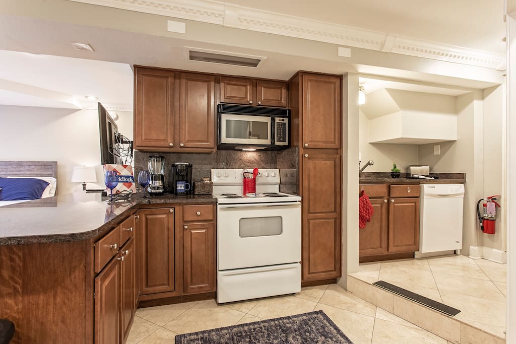 Kitchen is stocked with pots pans plates and utensils , complete with range, microwave, full-size refrigerator and dishwasher !