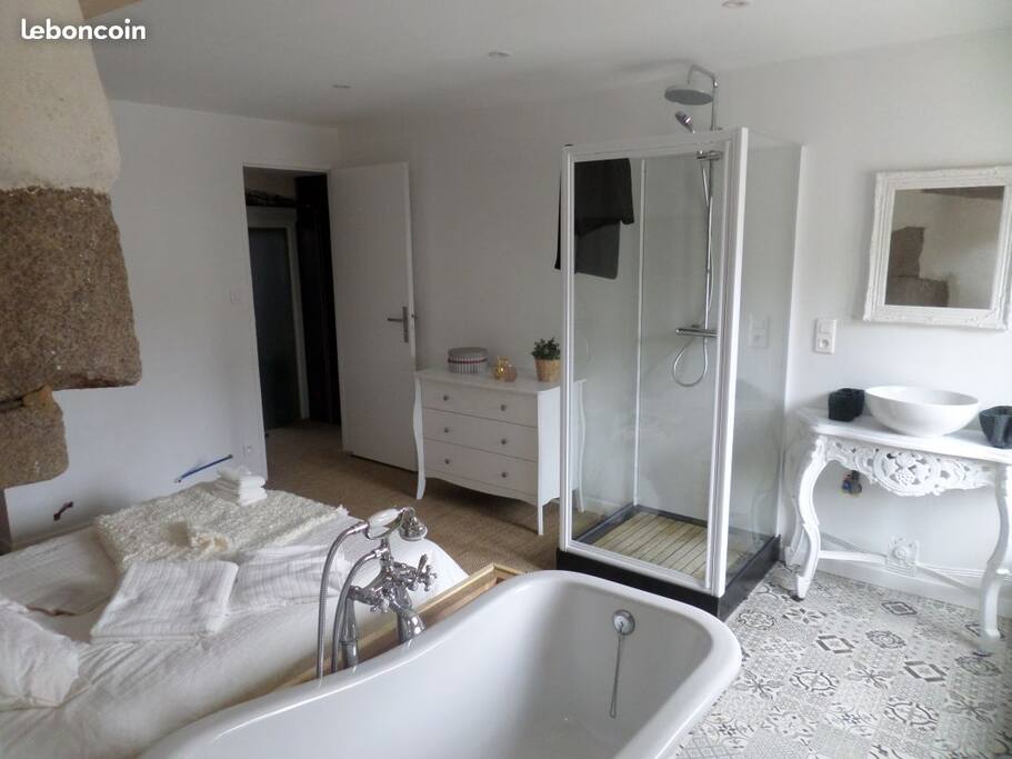 Suite parentale avec lit double et salle de bain ouverte, douche et baignoire
