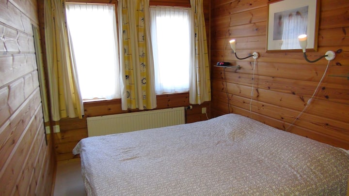 Amplio dormitorio en la planta baja con dos camas de una plaza y televisión de pantalla plana en la pared.