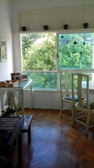 Sala bem ventilada com ampla janela e mesa de jantar.
Well ventilated room with large window and dinind table.