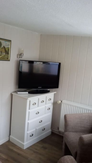 beheizbarer Wohnraum mit 2 Polstersesseln und 40" Flachbild-TV