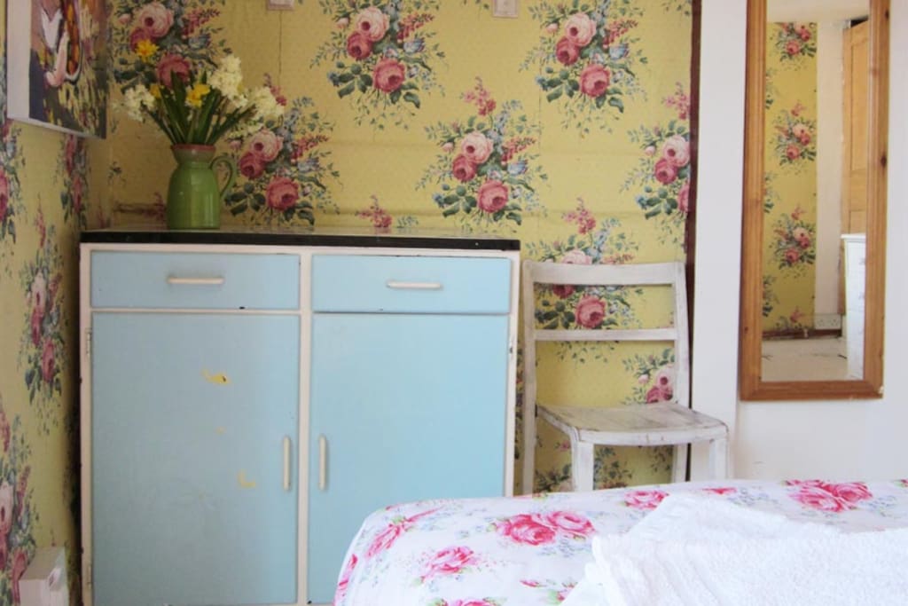 The room has a hanging wardrobe, a chest of draws and this vintage blue cupboard.