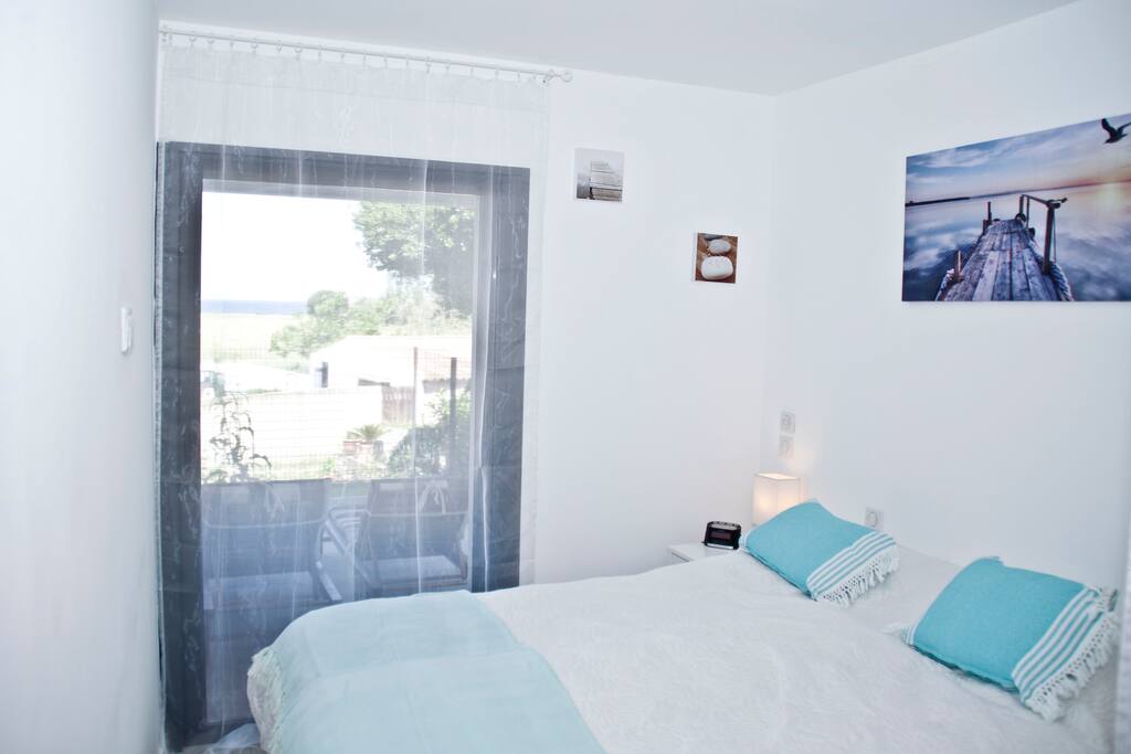 Chambre 2. Chambre parentale donnant sur la terrasse avec vue mer.