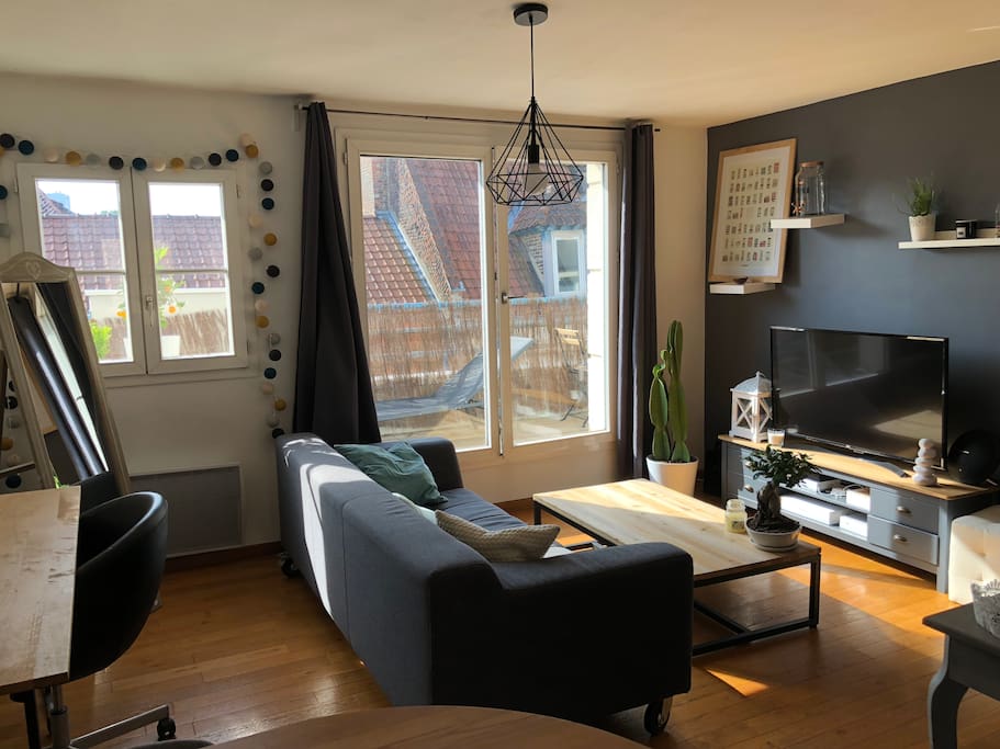 Beau salon avec espace bureau donnant sur un grand balcon