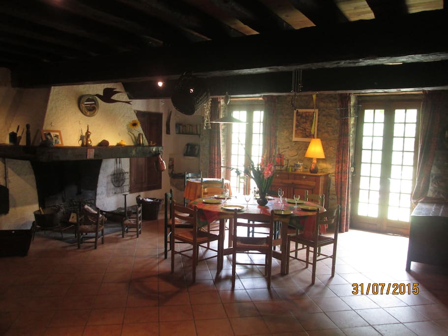 pièce de vie, (80 m²) avec sa grande cheminée. Accès direct avec la terrasse plein sud.