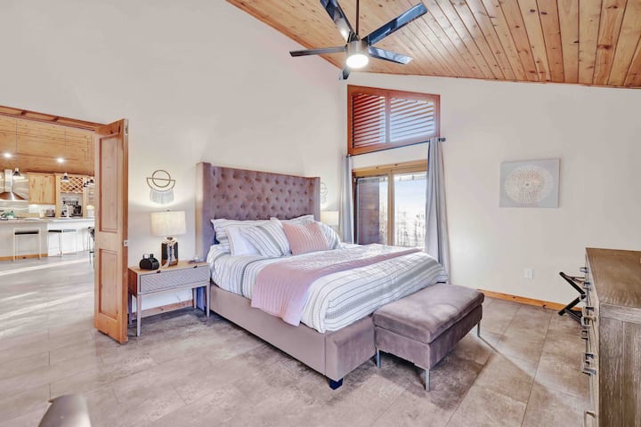 Основна спалня на горния етаж - луксозни чаршафи и завеси за затъмнение. Заедно със смарт телевизор и води до просторната палуба. 