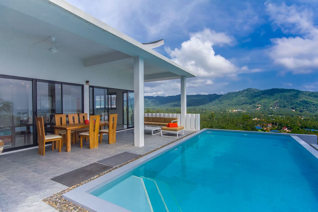 Grande terrasse, table de repas, au bord de la piscine, vue mer