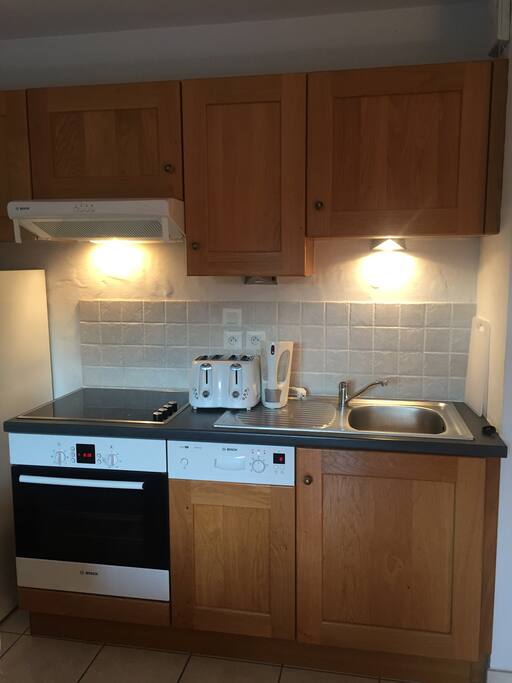 Kitchen area with dishwasher, full size oven, microwave and fridge freezer