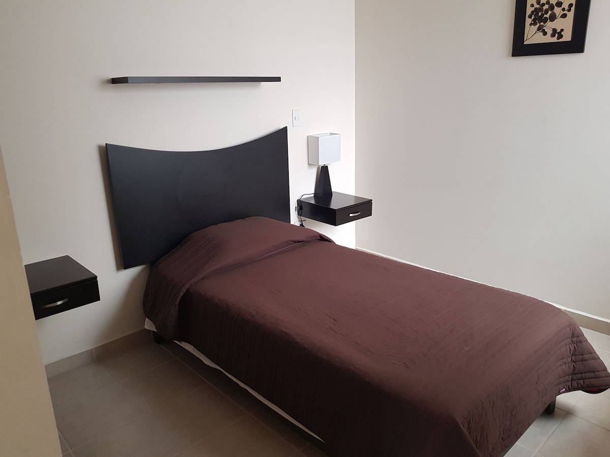 Recámara matrimonial con escritorio y guarda ropa.