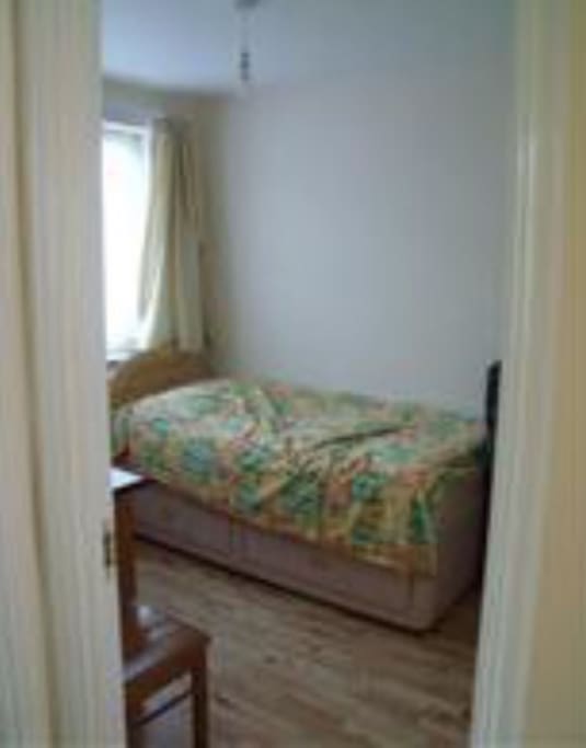 1 bedroom with single bed, desk and basic wardrobe for clothes.