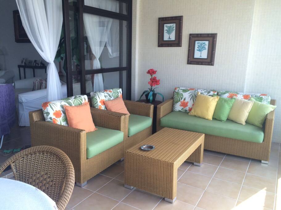 Terraço confortável com sofá e mesa para refeições