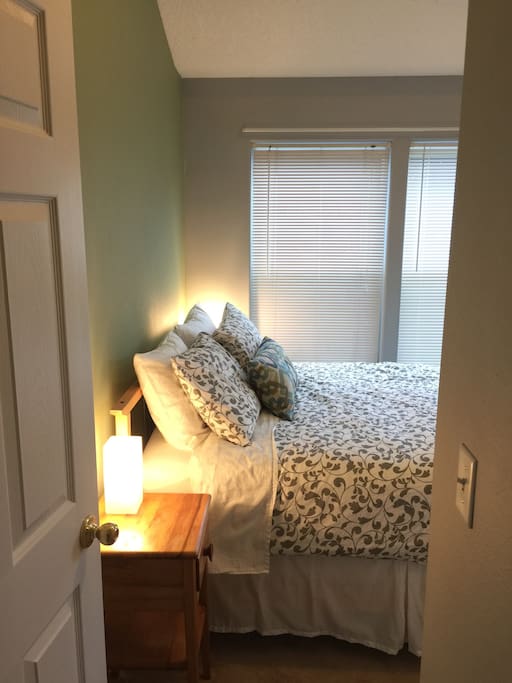 One of two bedrooms with a queen bed and small workspace