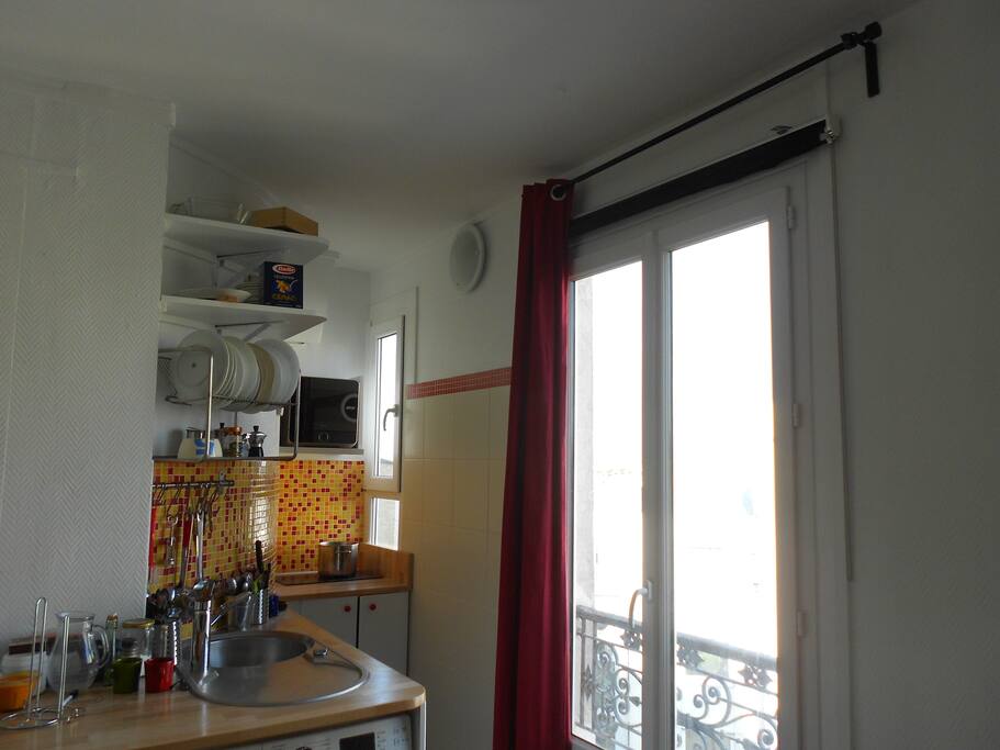small kitchen with a washing machine, microwave, fridge, hob...