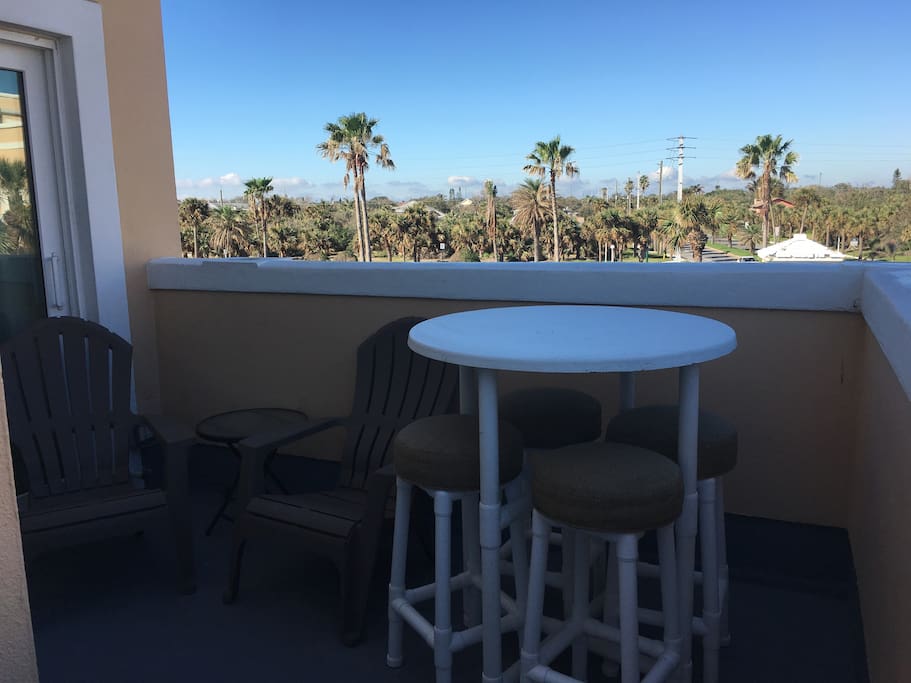 Large balcony with bar stools and lounging chairs