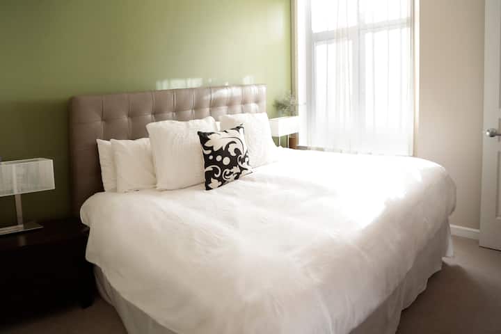 Duerme profundamente en una cama California King con ropa de cama blanca fresca y un lujoso edredón de plumas.