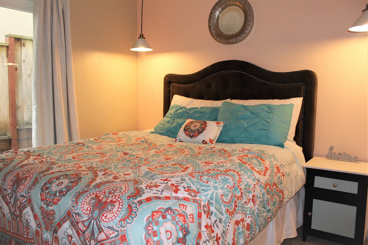 Dormitorio número 2: dos luces colgantes bajan del techo para encender el hermoso color melocotón. Hay mesitas de noche a cada lado de la cama.