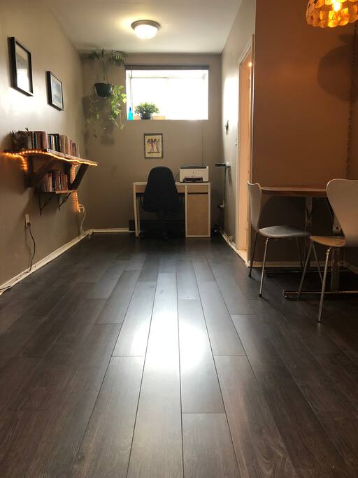 The middle section of the living area, adjacent to the dining nook, with a laptop friendly workspace and plenty of books.