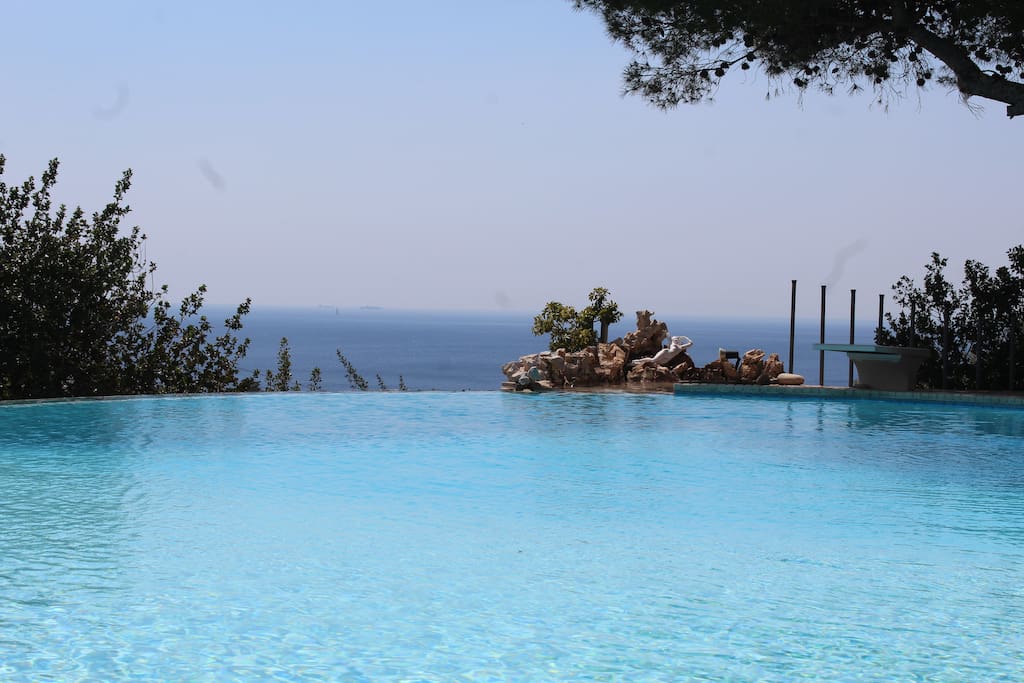 infinity pool overfloats towards the blue sea