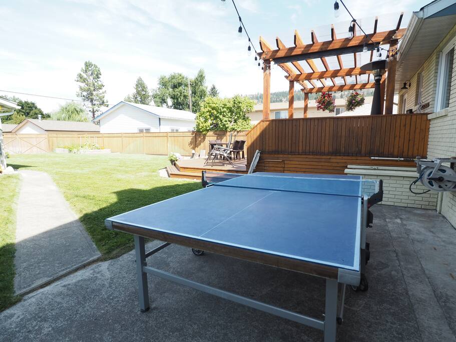 The table tennis table is situated right outside the kitchen and living room