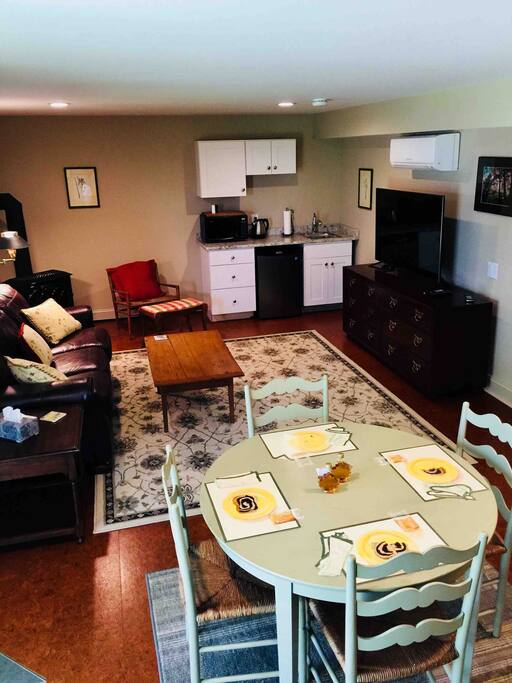 Cozy Great Room area, with access to back yard and complete with gas stove, AC, work desk, eating area, mini-kitchenette, 52 inch screen TV and comfy leather couch.