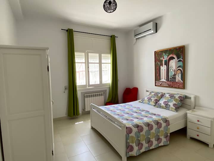 Chambre à coucher climatisée avec espace de rangement (placard et table de chevet) et volets roulants - se trouve au rez-de-chaussée. 
